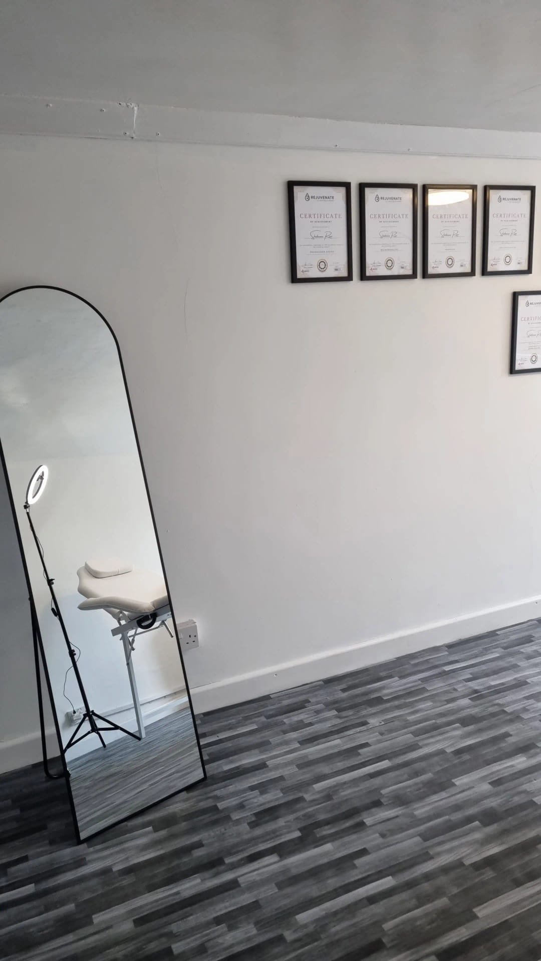 Certificates on the clinic wall with full-length mirror
